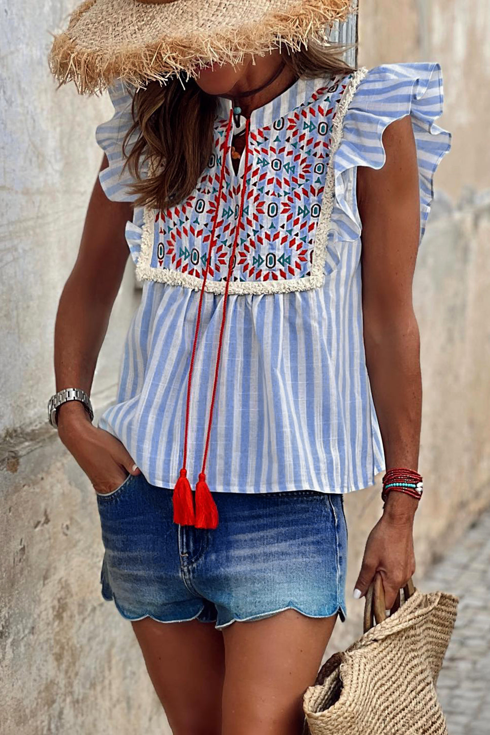 Blusa con aleteo y borlas bordadas con patrón geométrico de rayas azul cielo