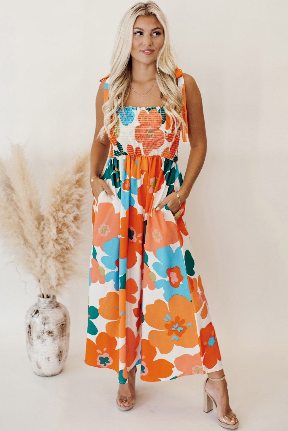 Robe longue orange à fleurs et bretelles nouées au buste smocké