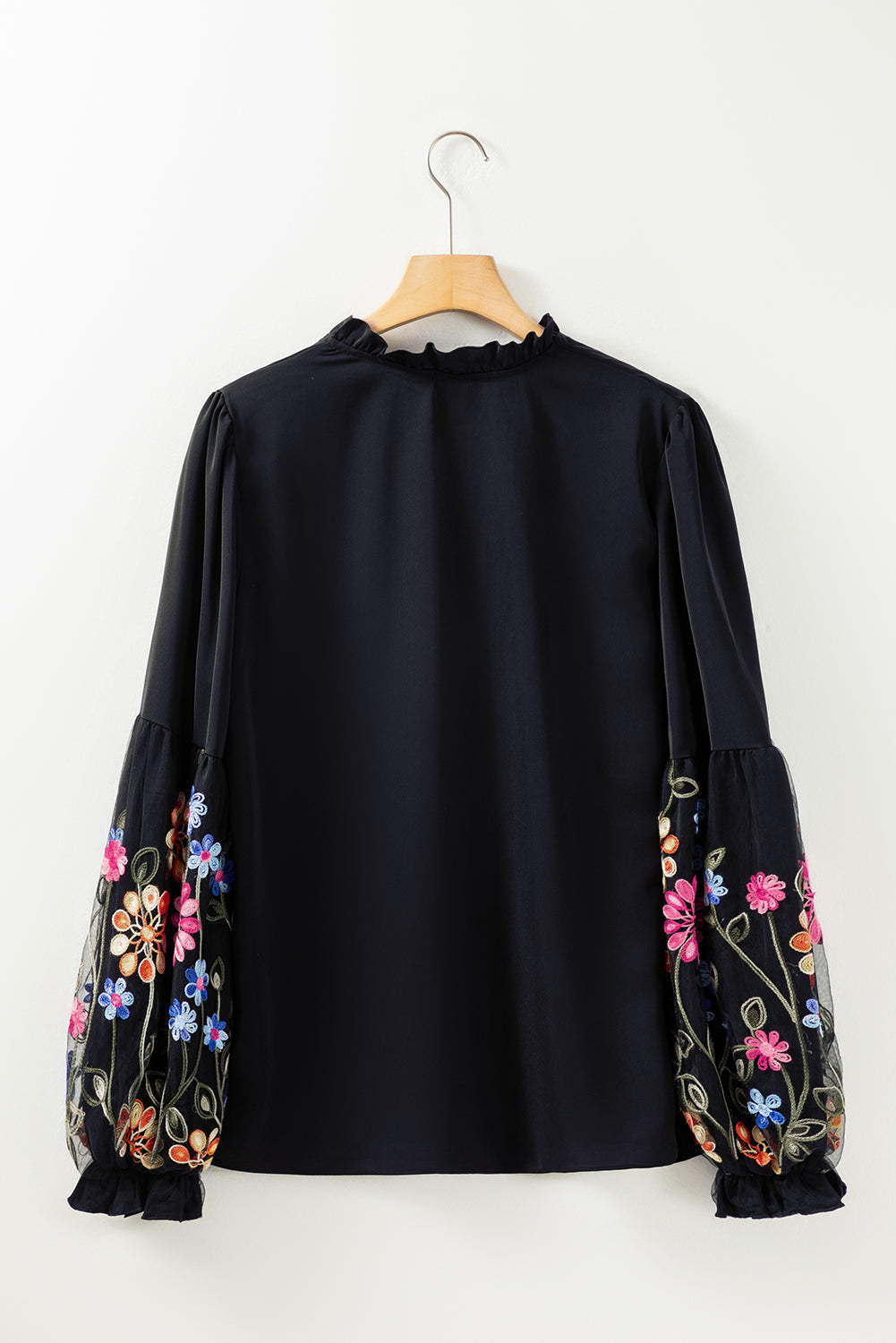 Blusa con cuello dividido y manga con volante y parche floral negra