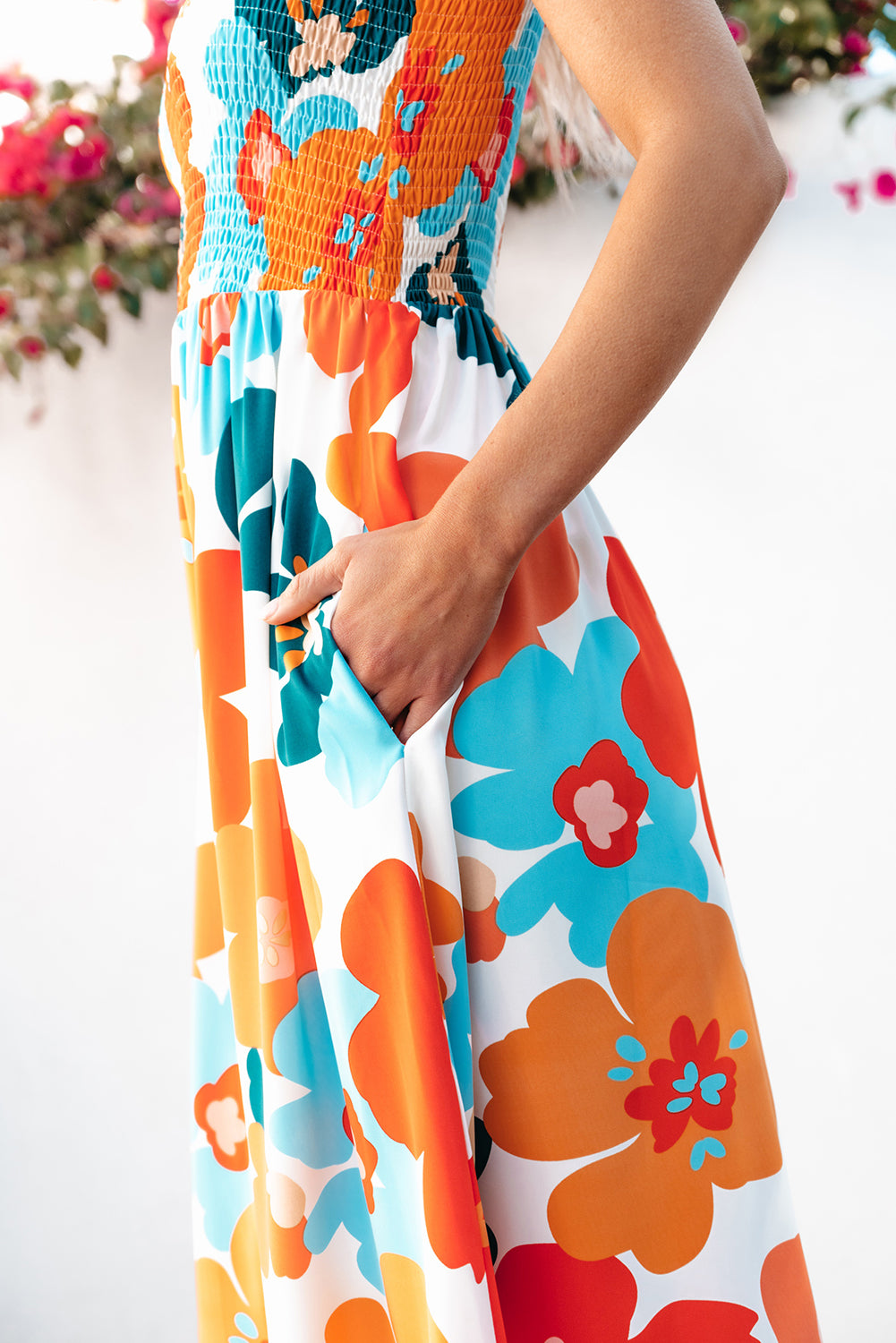 Robe longue orange à fleurs et bretelles nouées au buste smocké