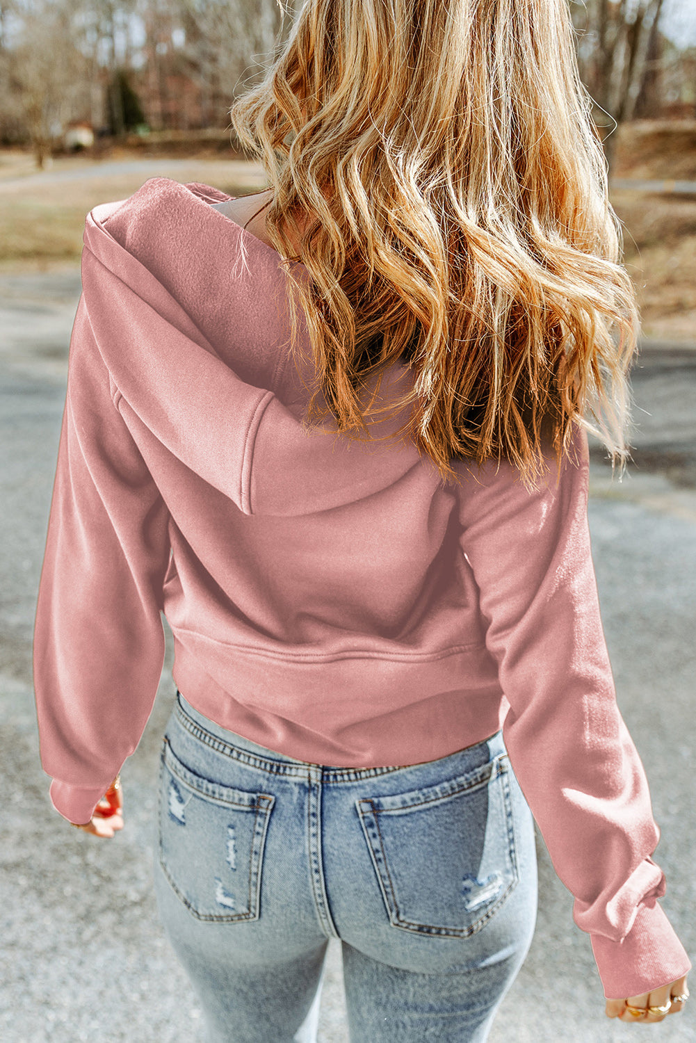 Sweat à capuche rose avec poche kangourou et fermeture éclair sur un quart