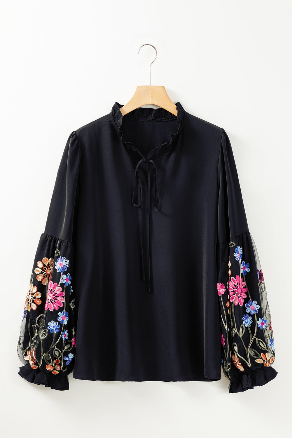 Blusa con cuello dividido y manga con volante y parche floral negra