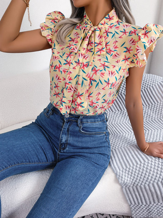 Blusa con mangas abullonadas y cuello con lazo floral