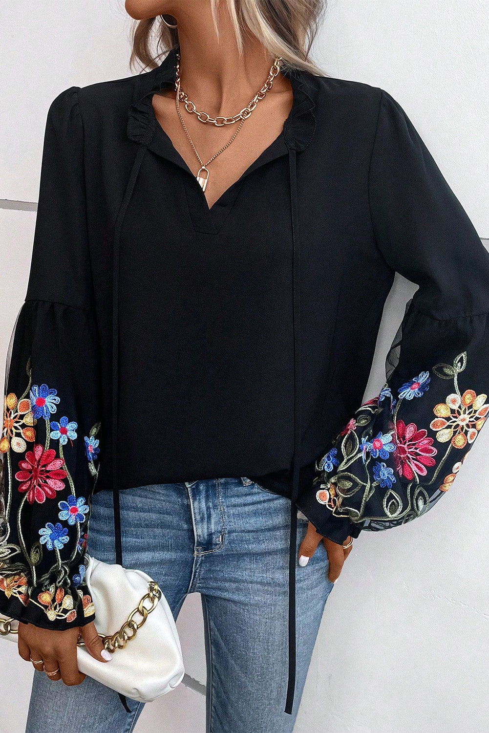 Blusa con cuello dividido y manga con volante y parche floral negra