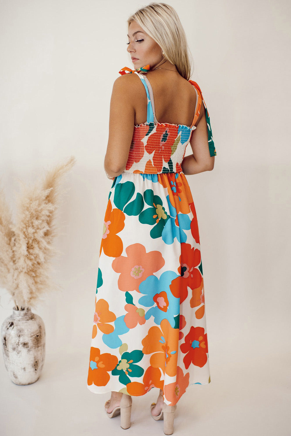 Robe longue orange à fleurs et bretelles nouées au buste smocké